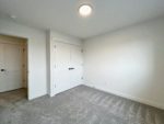 An empty room with a flat profile ceiling fixture with a carpeted floor.