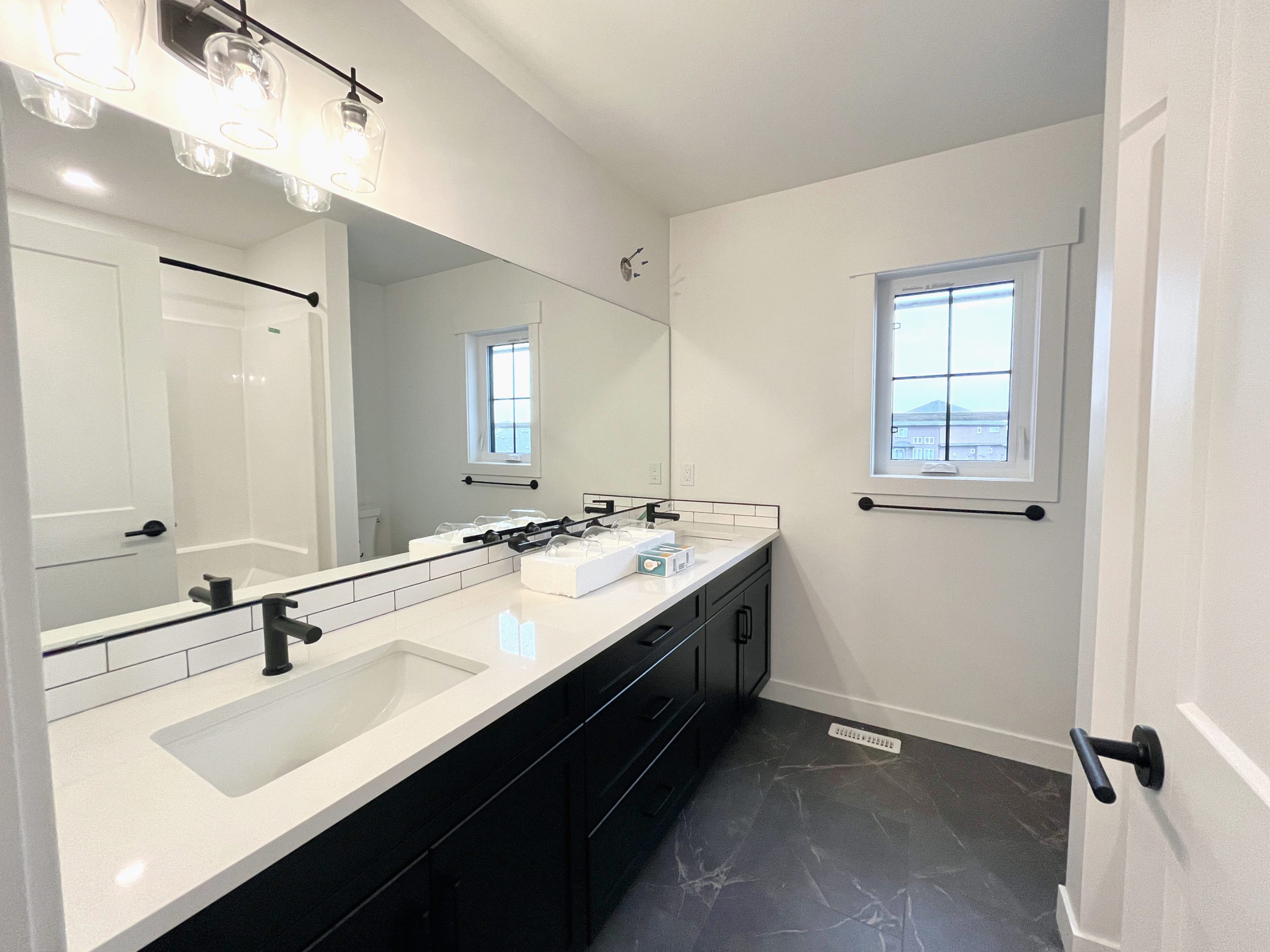 A family bathroom with double sinks and a large mirror.