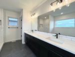 An ensuite bathroom with double sinks and a large mirror.