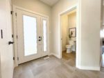 Shows the main entryway with closet doors and access to main floor powder room.