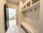 A mudroom with a built-in bench and several hooks on the wall.