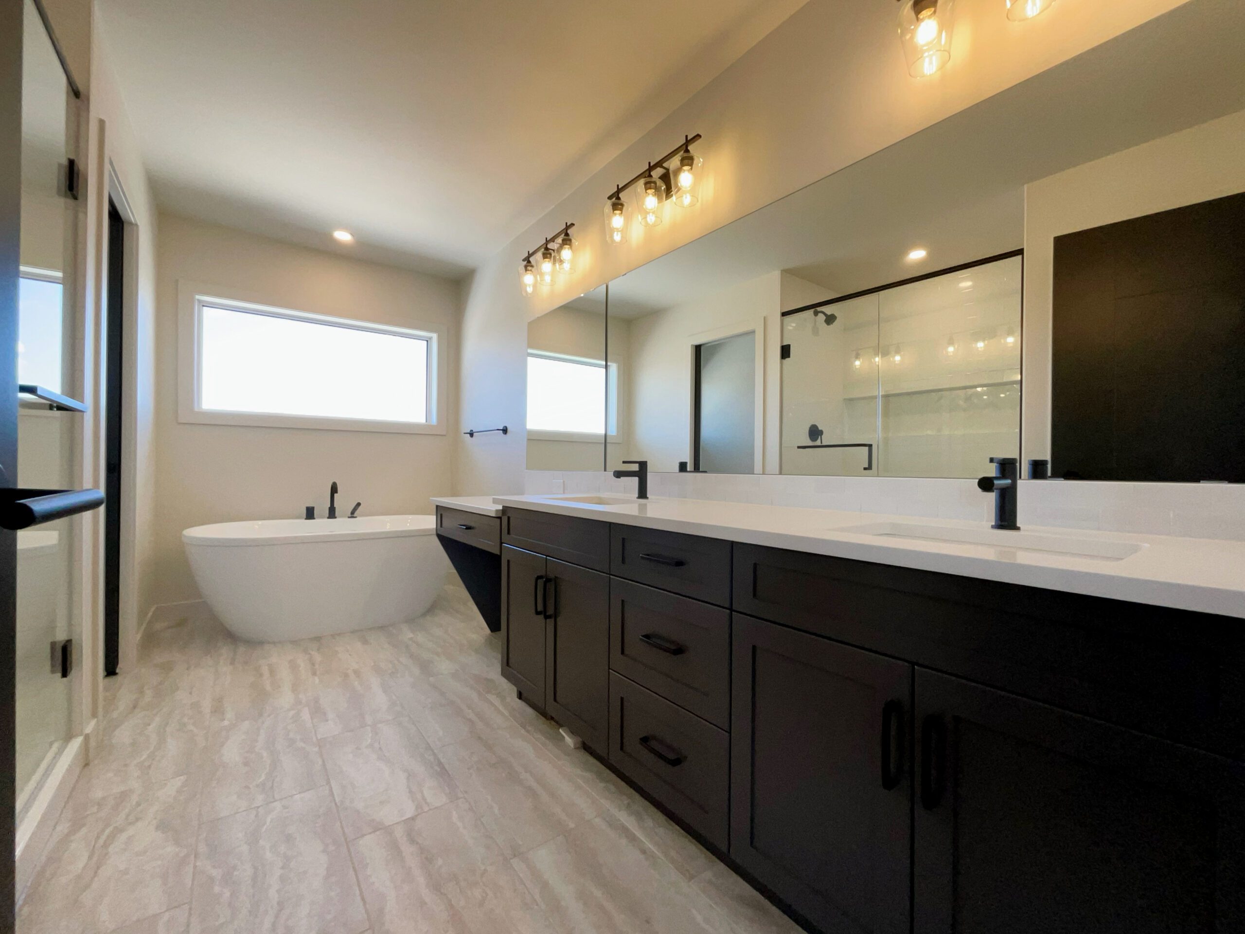 The large primary bathroom with a freestanding tub, double sinks, walk-in shower and mirror.