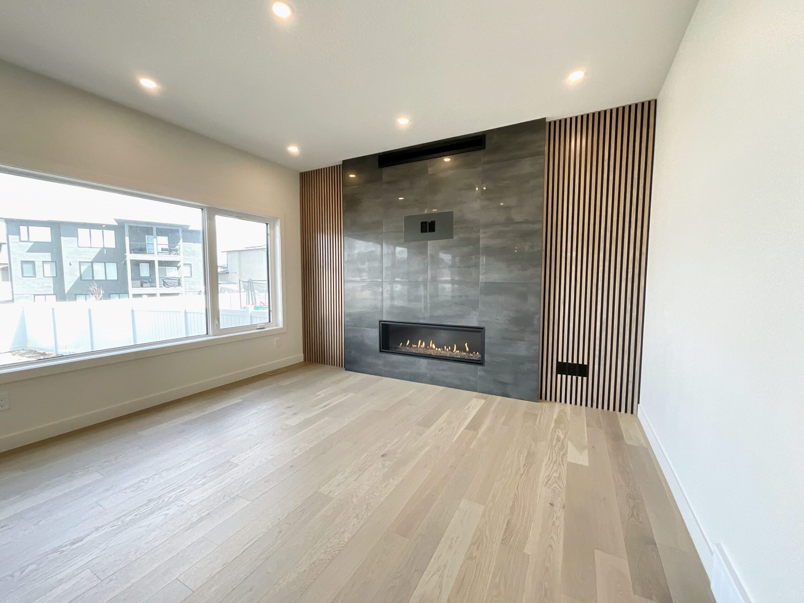 A large empty living room with a fireplace in it.