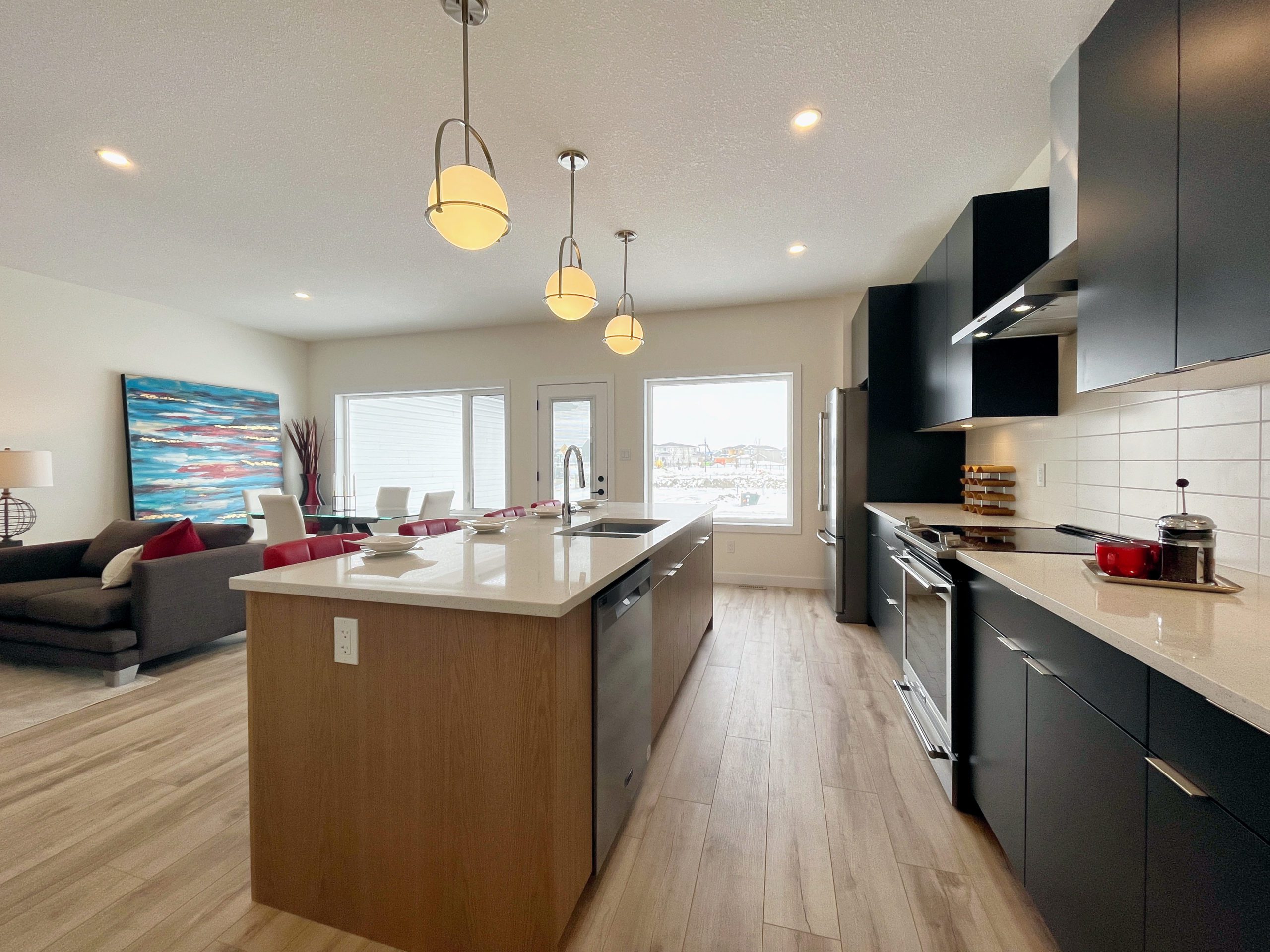 Shows the kitchen with a center island adjacent to open-concept living space.