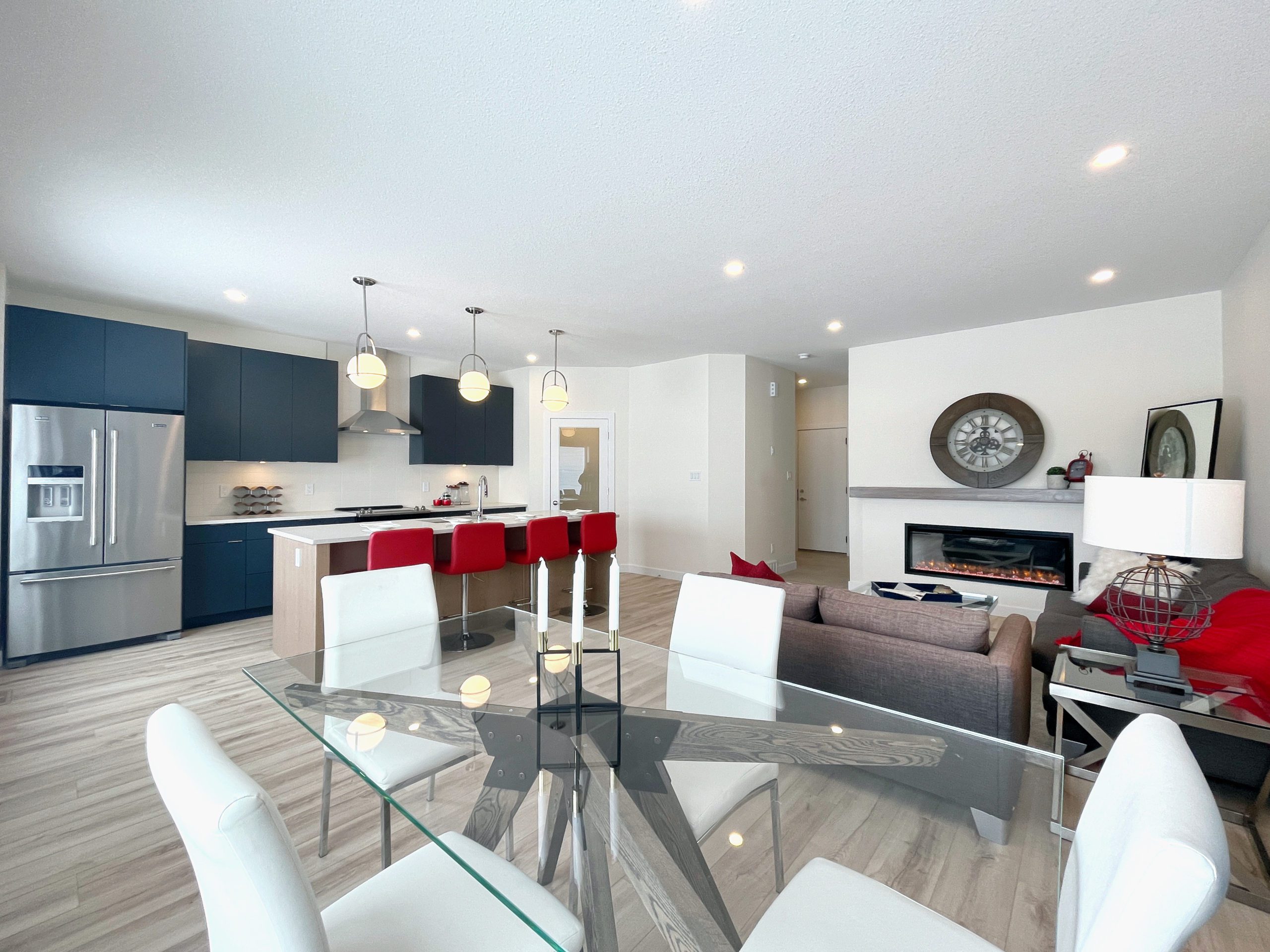 A modern townhome with a glass table in the open concept living area looking over the kitchen and living room.