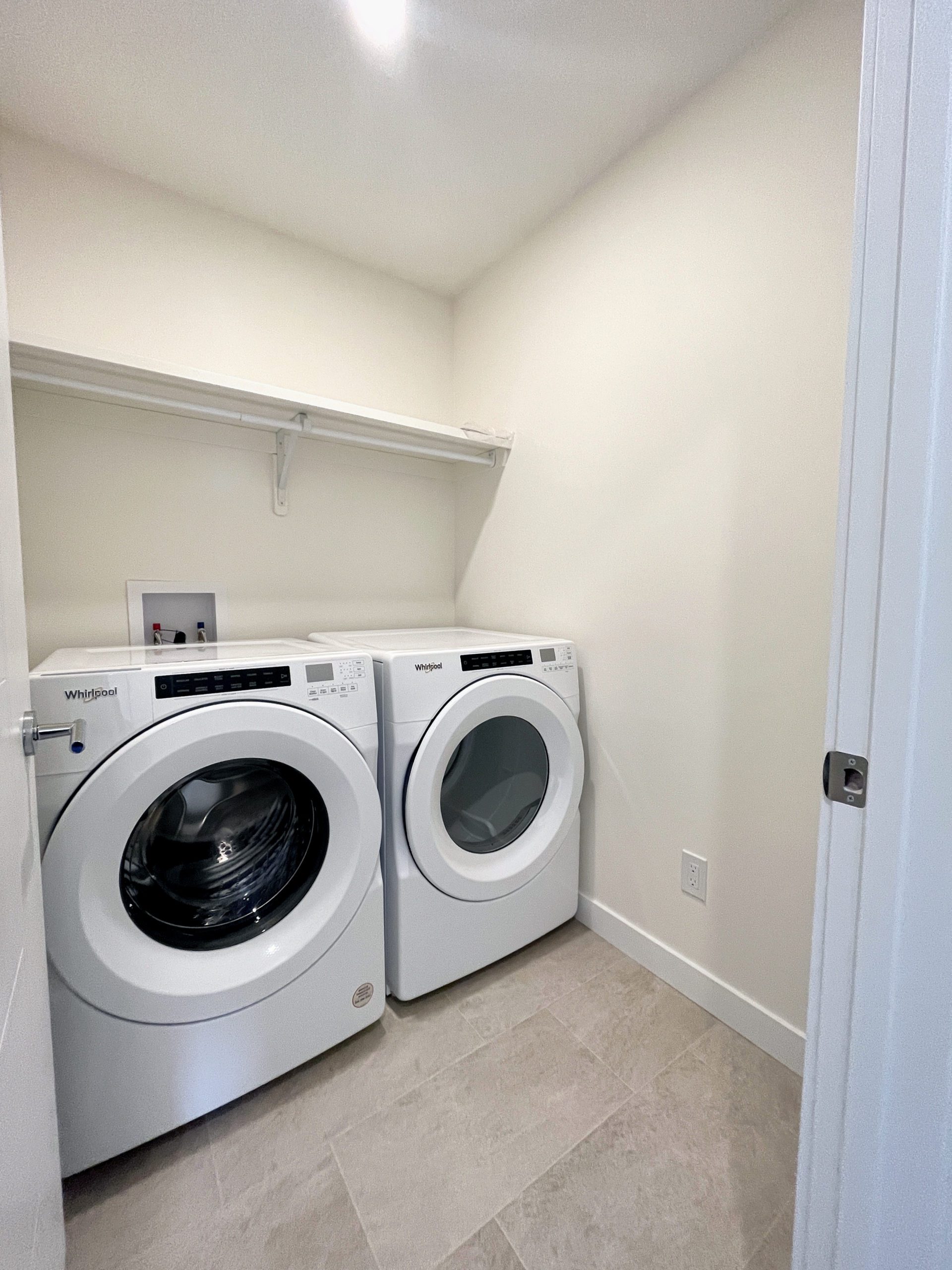 A side-by-side front-load washer and dryer in the upstairs laundry room.