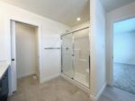 A walk-in shower and sink in a the townhome primary ensuite.