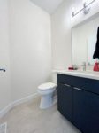 A bathroom sink and white toilet in the main floor powder room.