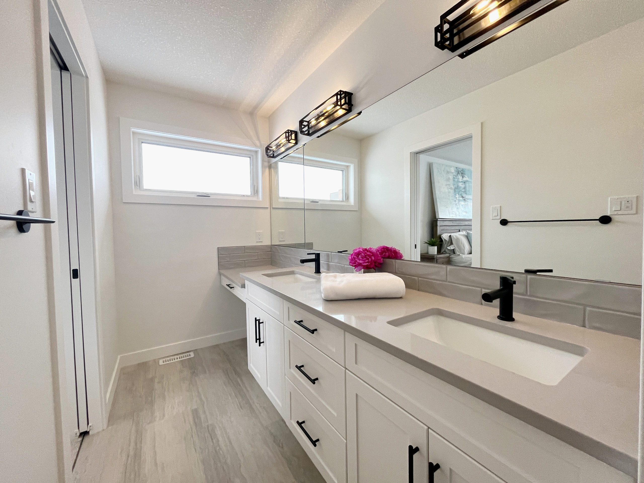 The primary ensuite bathroom with double sinks, makeup counter and mirrors.