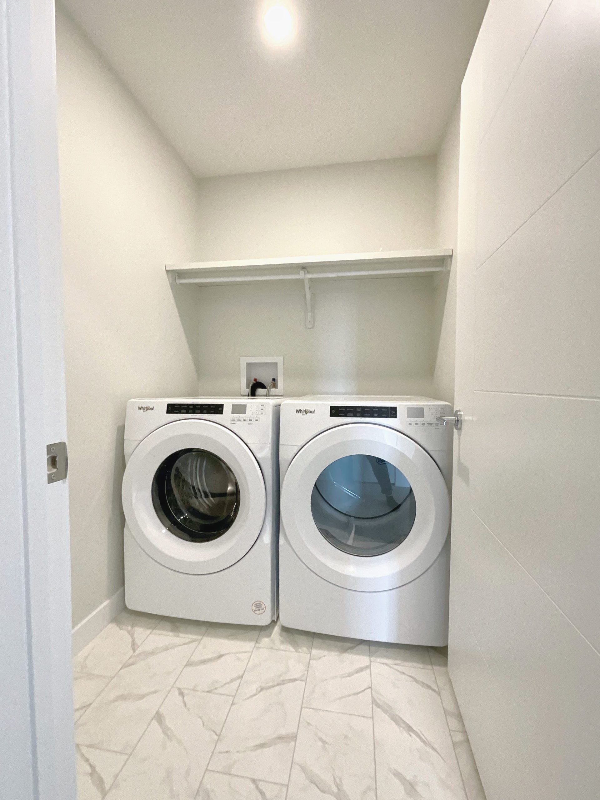Upstairs laundry room with side-by-side front load washer and dryer.