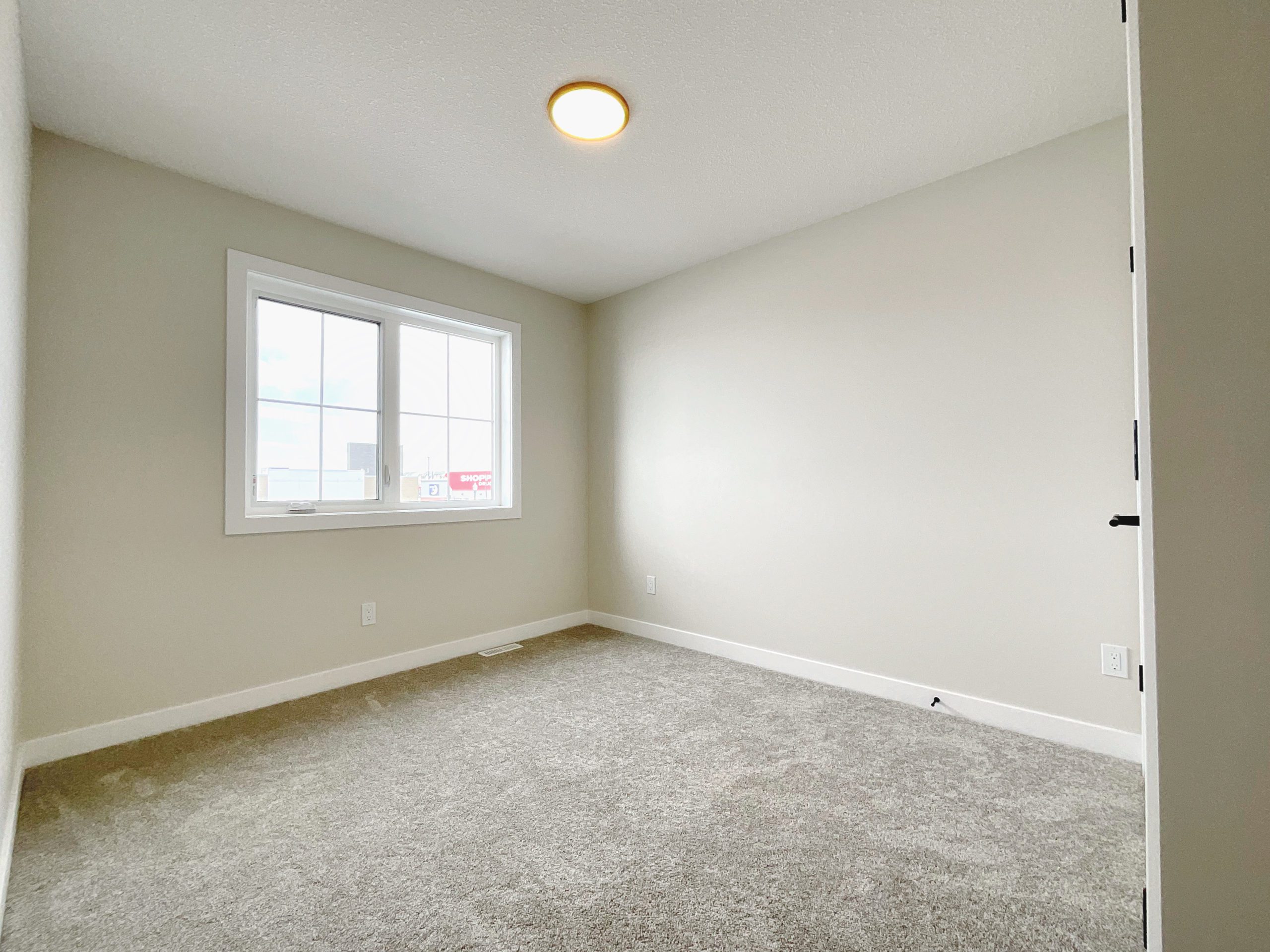 Shows an empty bedroom with window.