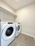Shows upstairs laundry room with side-by-side front load washer and dryer.