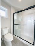Shows primary ensuite water closet with white toilet sitting next to a walk in shower.