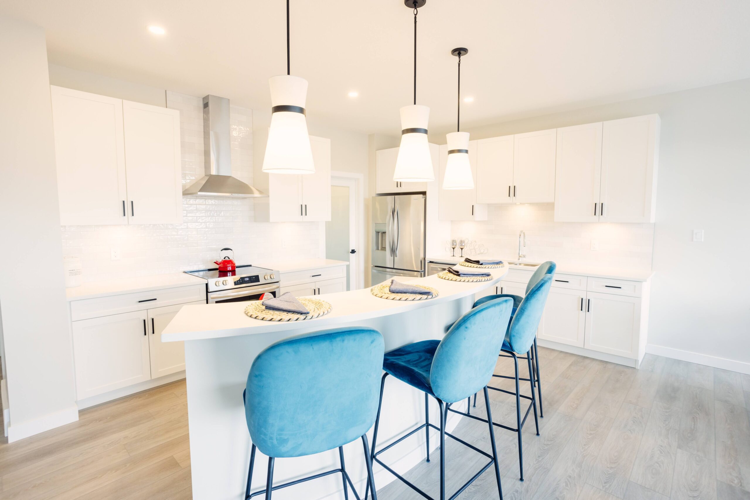 A kitchen with blue chairs and white cabinets.