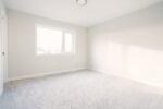 Empty room with white carpet and window.