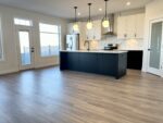 A kitchen with hardwood floors and black appliances.