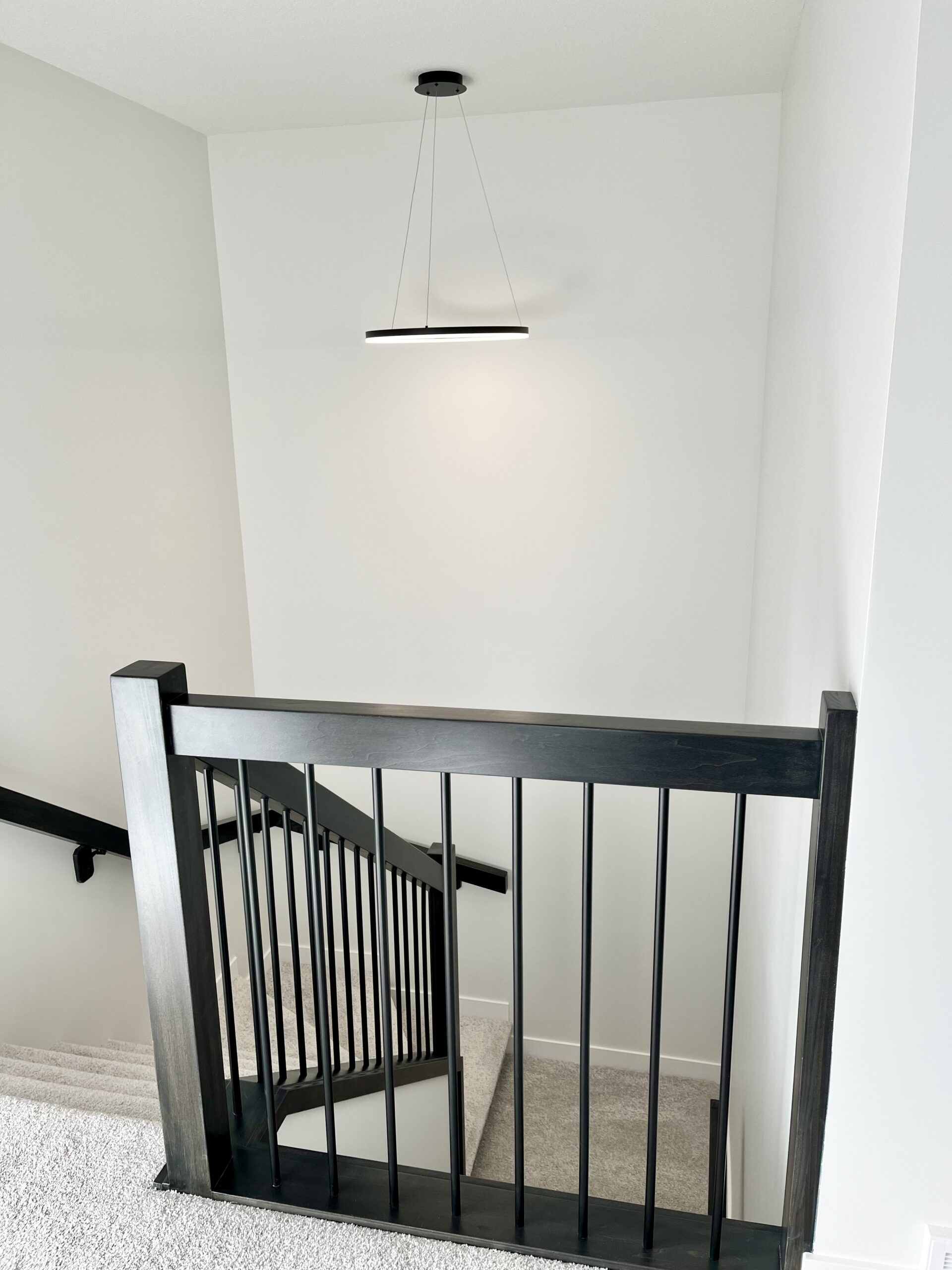 A staircase with a black railing.