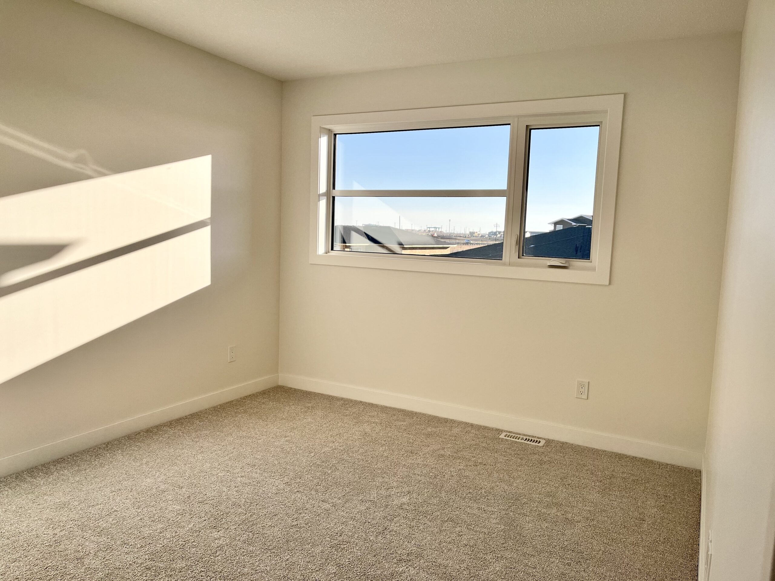 A room with a window and carpet.
