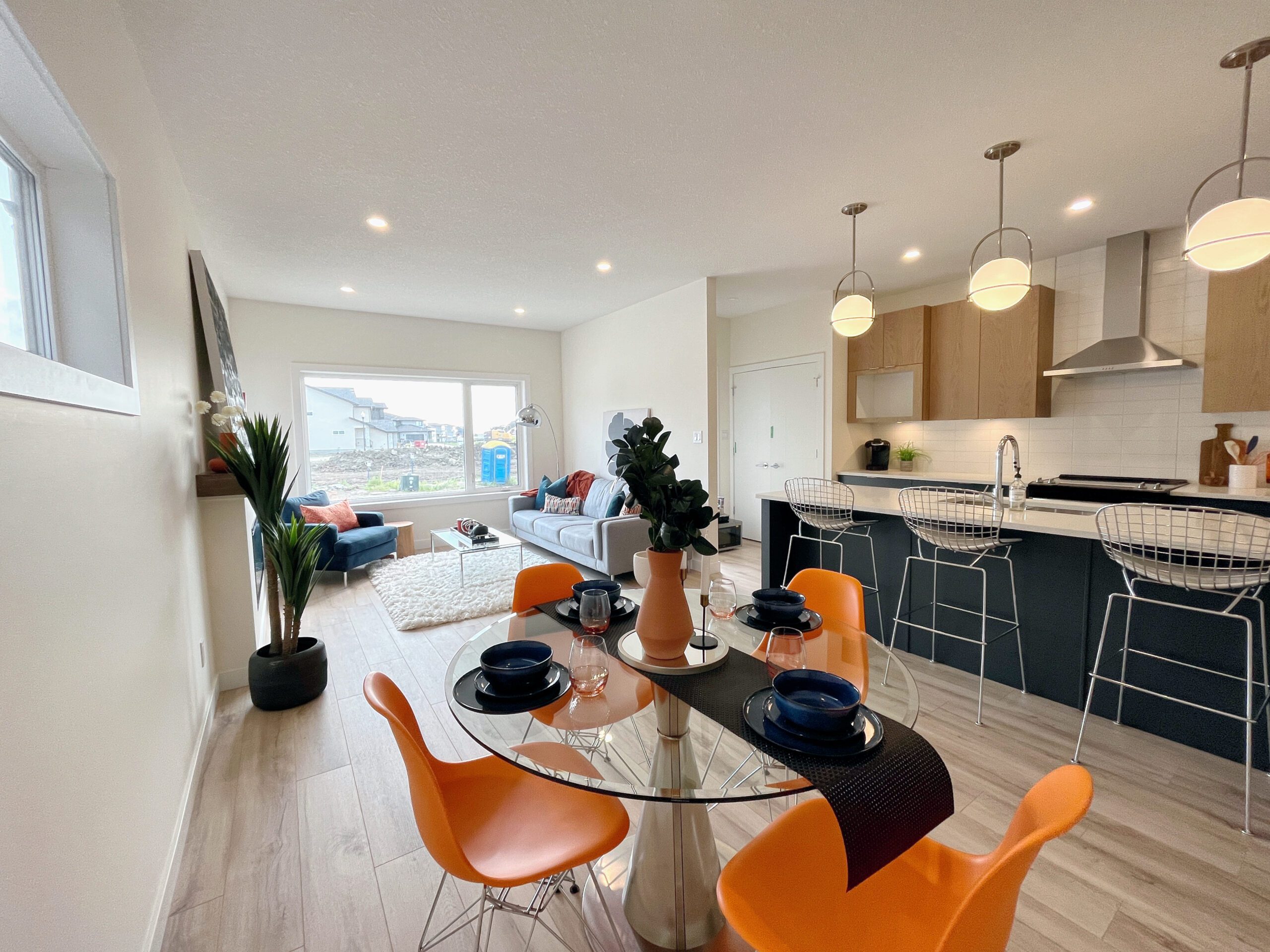 a kitchen with orange chairs and a dining table.