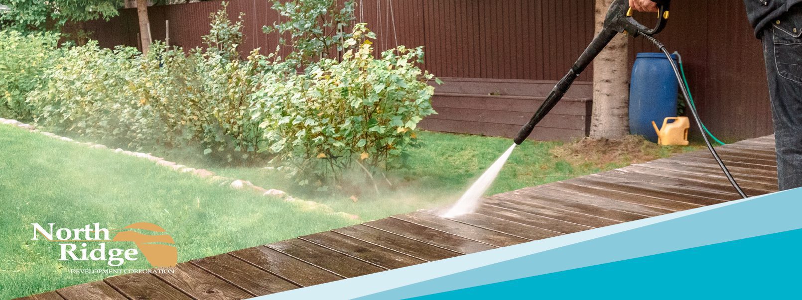 a man is using a pressure washer on a deck.