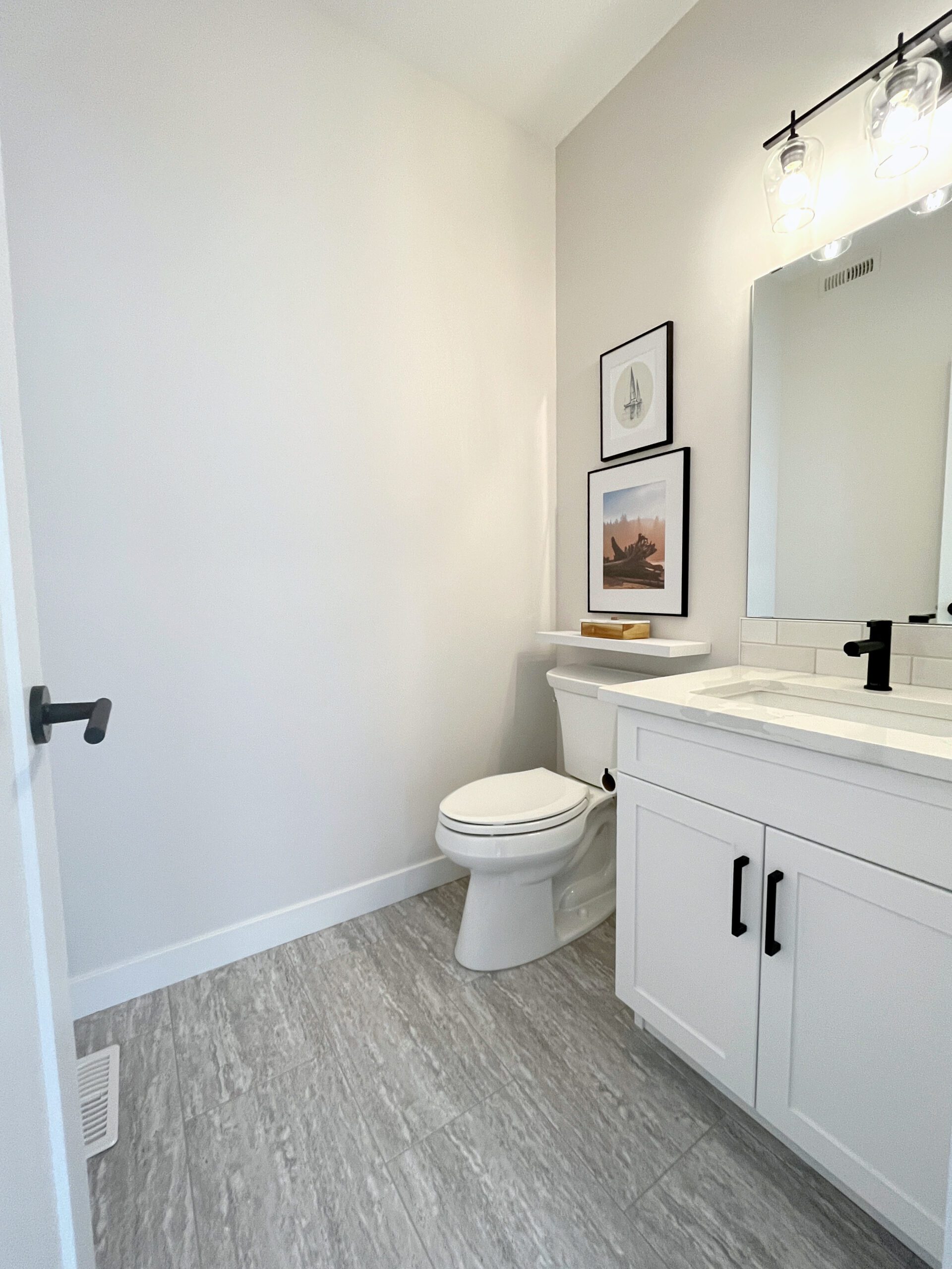 A two-storey home in Pilot Butte with a white bathroom featuring a toilet and sink.