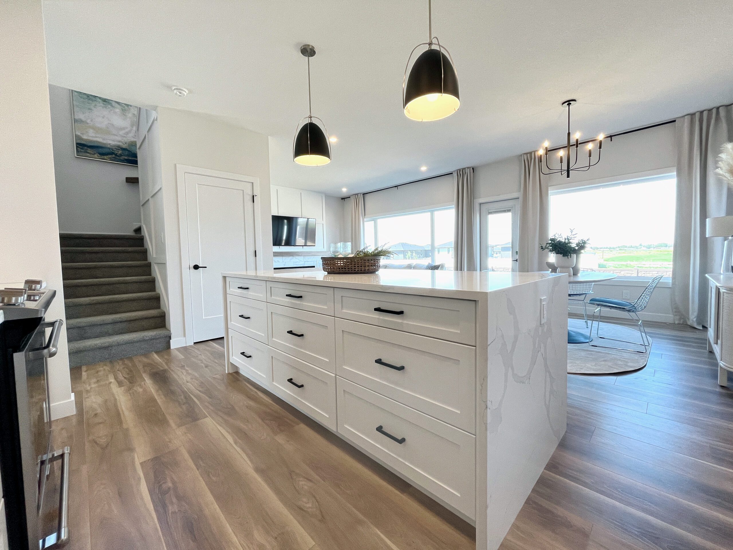 A two-storey home in Pilot Butte with white cabinets and hardwood floors.