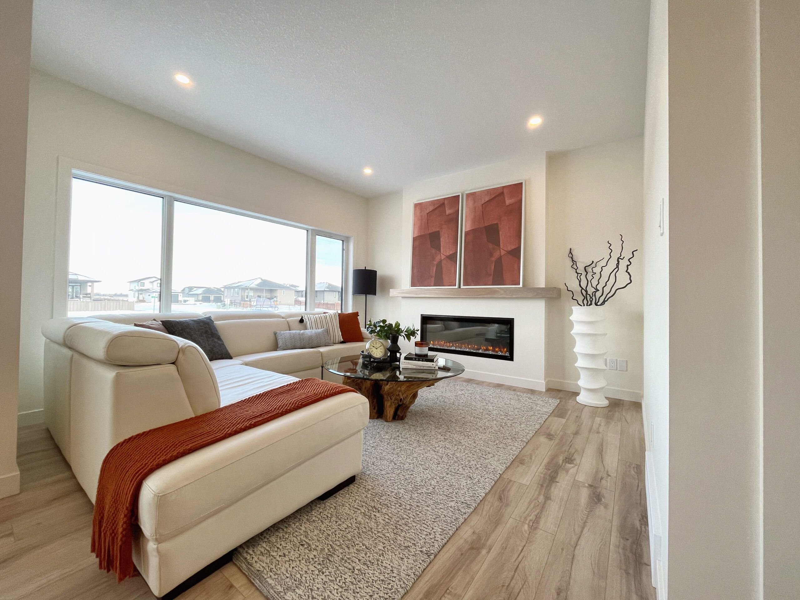 A cozy living room with a fireplace and a couch in a two-storey home in Pilot Butte.