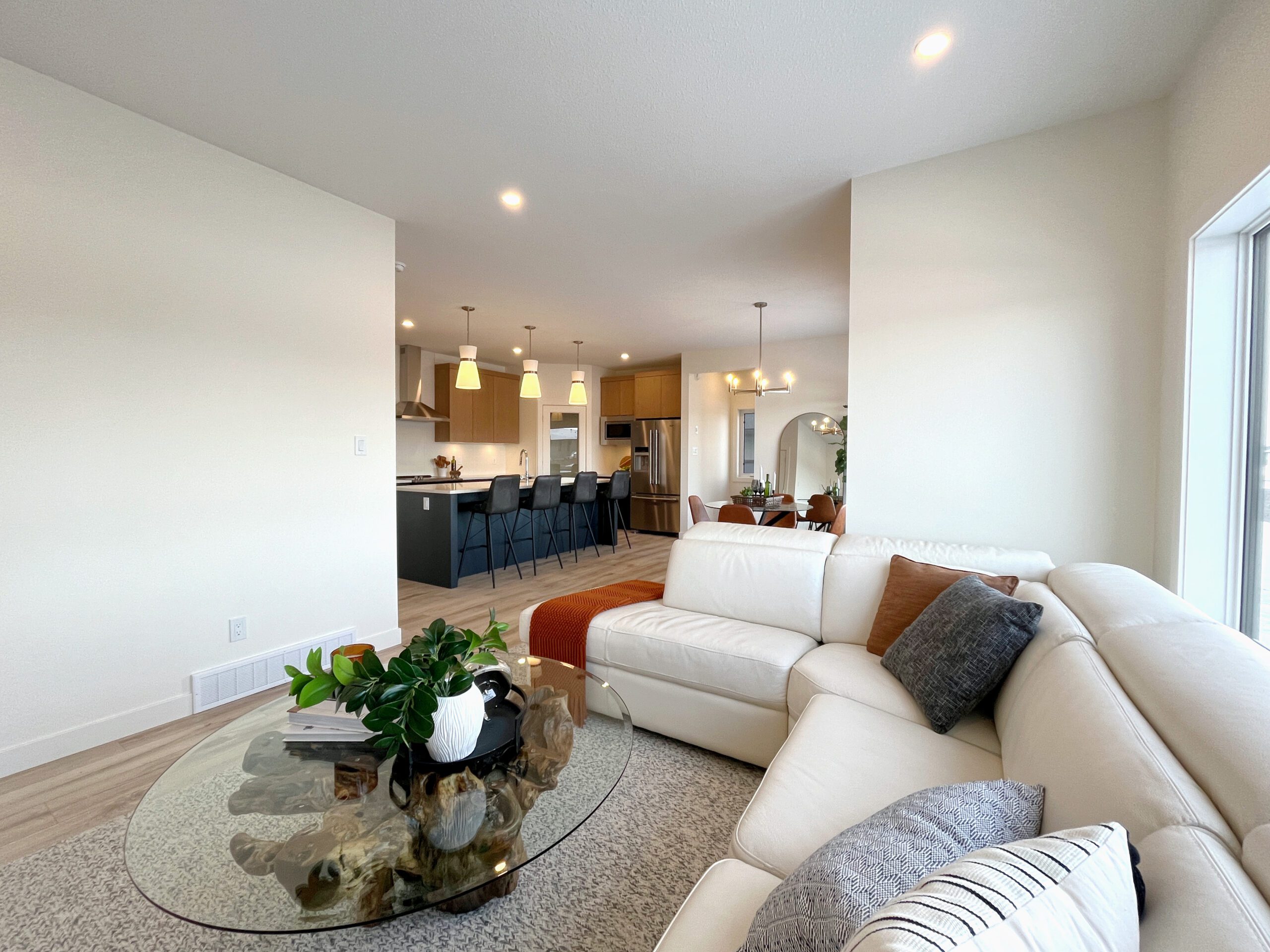 A two-storey home in Pilot Butte with a white couch and a glass coffee table.