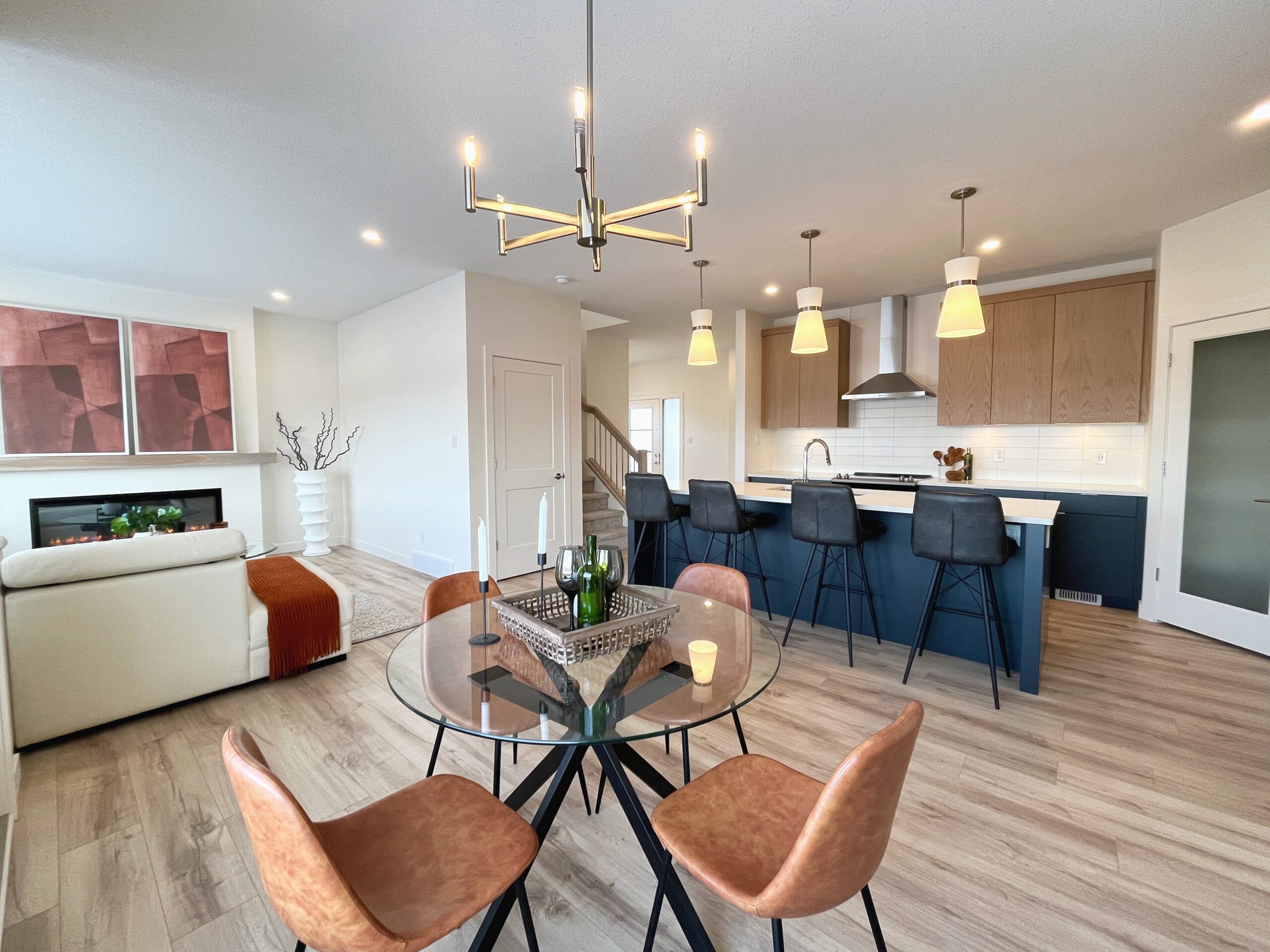 A two-storey home in Pilot Butte featuring a dining room and kitchen with a table and chairs.