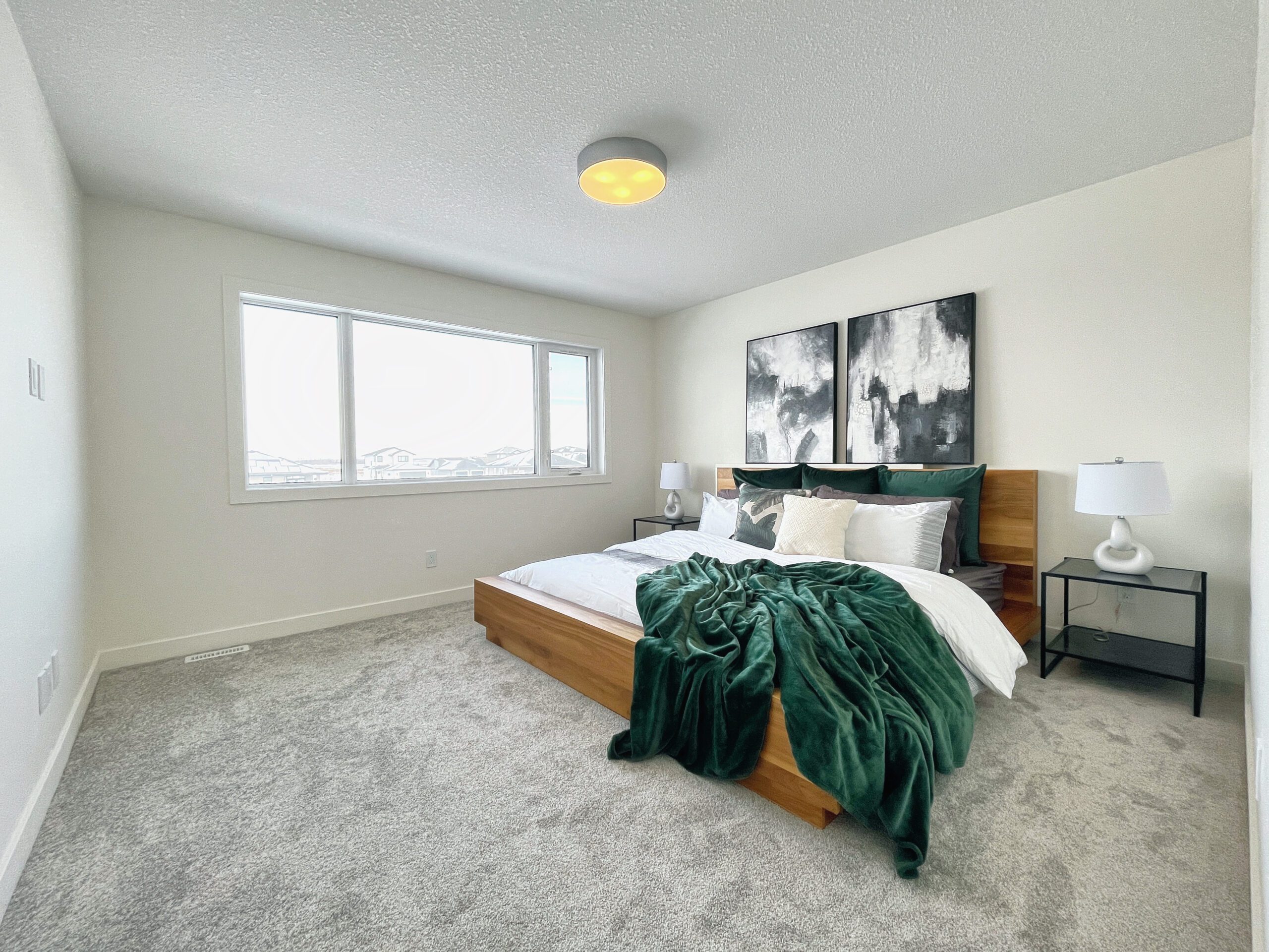 A two-storey home in Pilot Butte with a bedroom featuring a bed and a window.