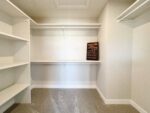 A walk in closet with shelves and shelves.