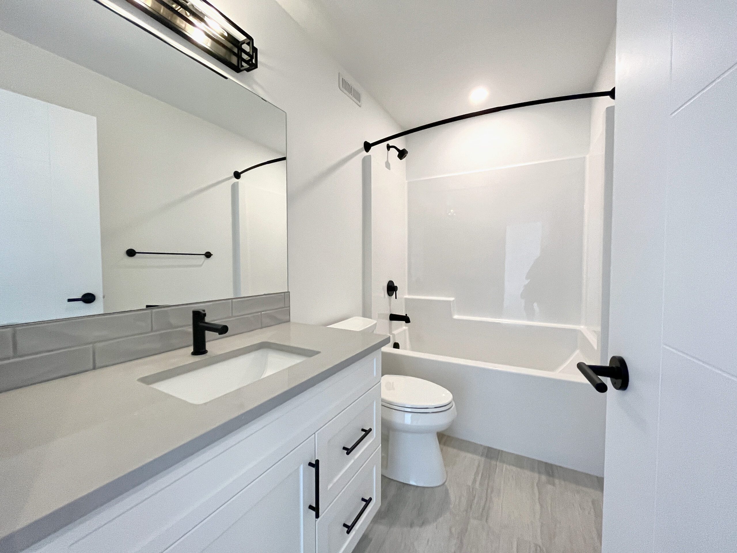 A white and gray bathroom with a toilet and sink.