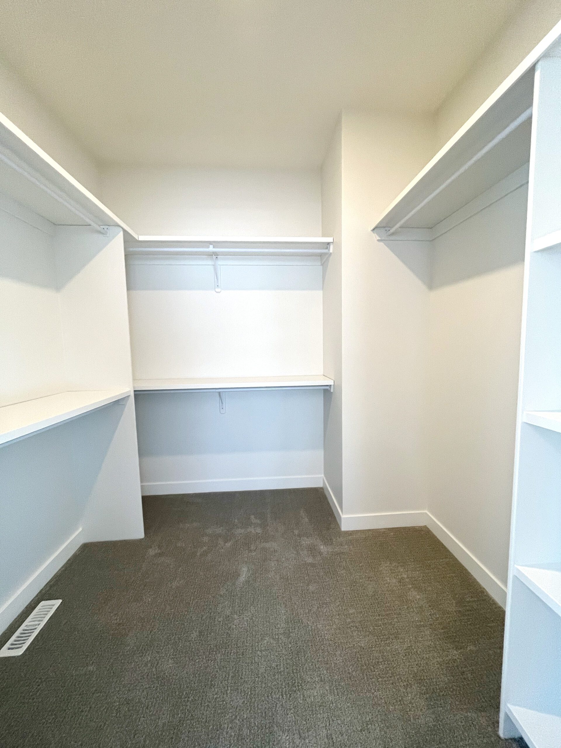An empty walk in closet with shelves and shelves.