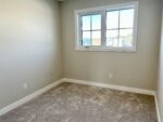 An empty room with carpet and a window.