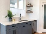A kitchen with gray cabinets and a sink.